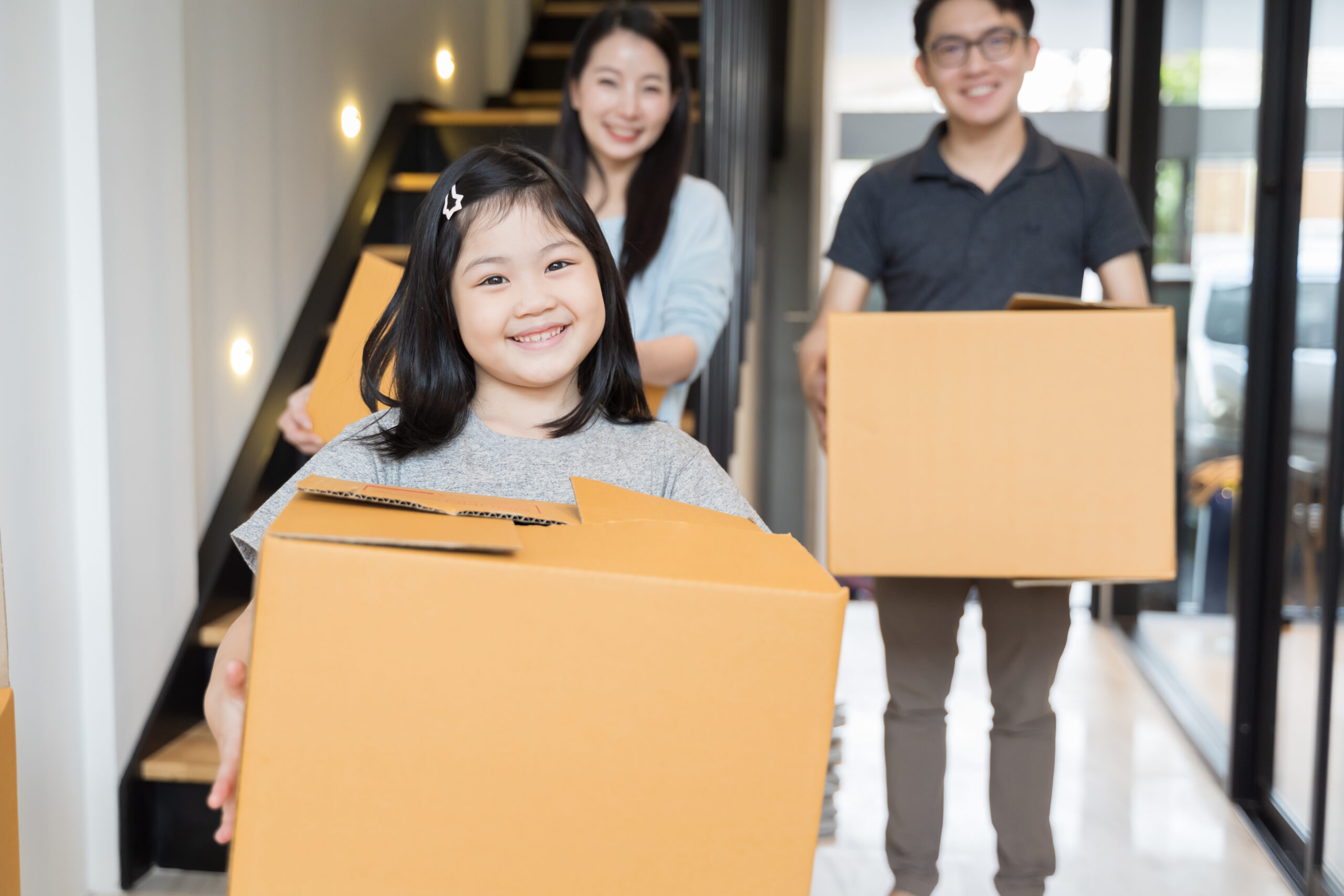 Asian family golding moving boxes