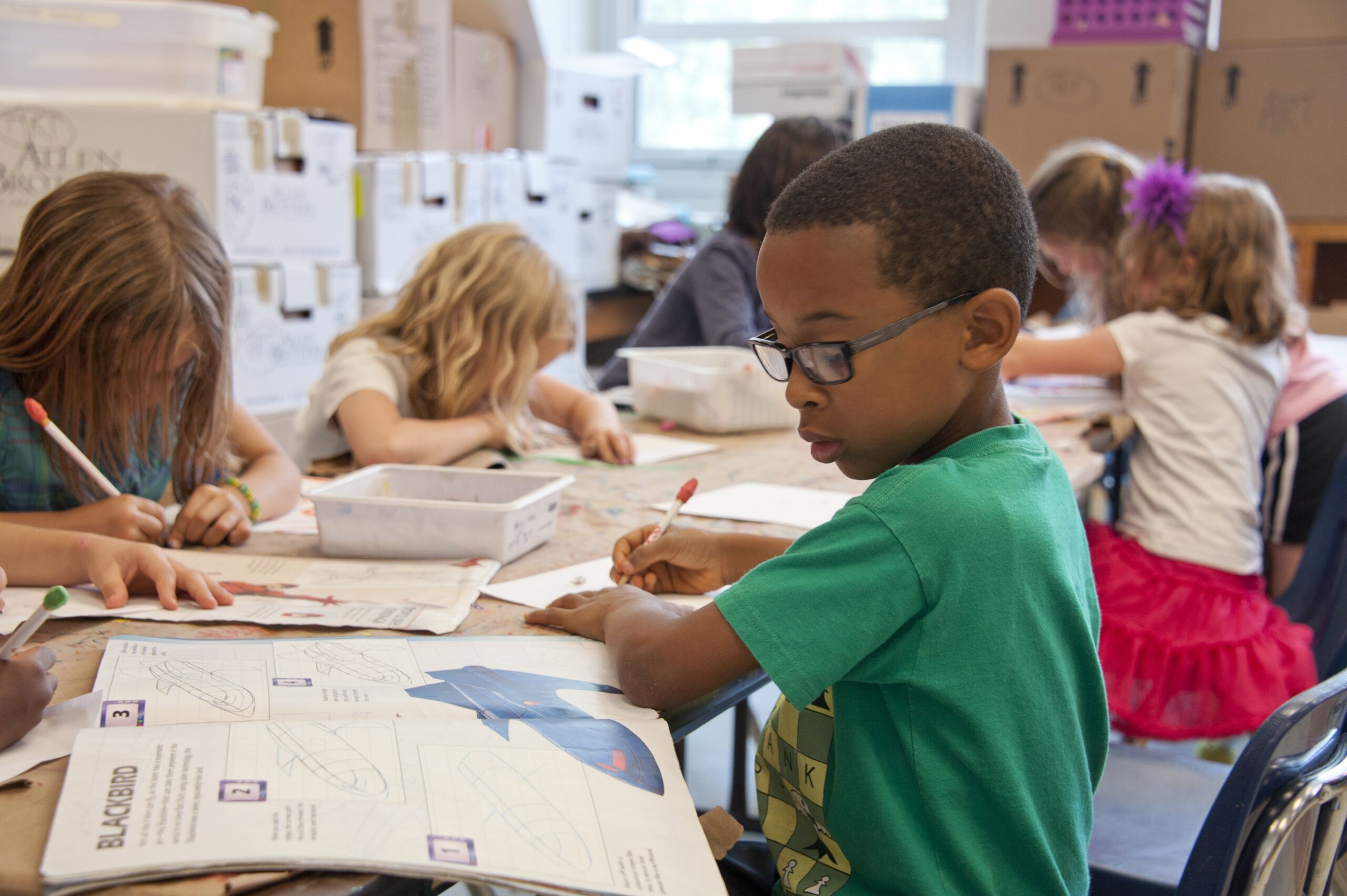 Child in class learning from a book