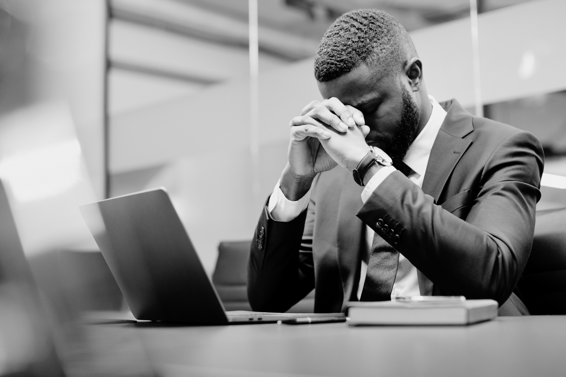 Unhappy employee worker at his desk black and white image